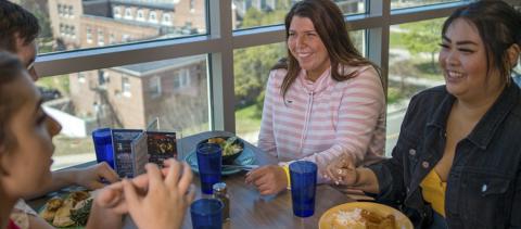 Group of students eating during summer at Holloway Commons